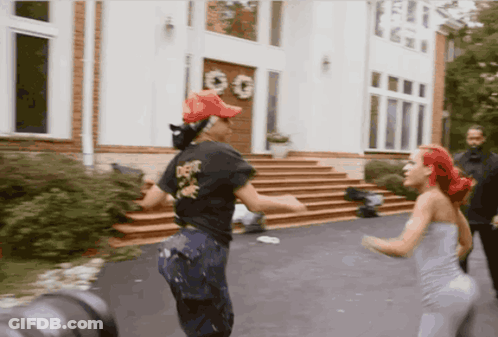 Two Women Dancing In Front Of White House With GG Sign GIF