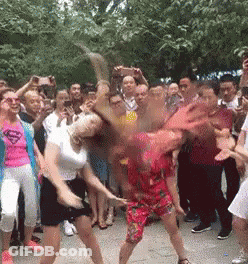 Two Women Dancing, One In Superman Shirt GIF
