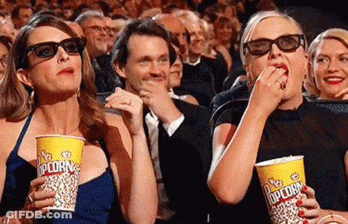 Two Women Eating Popcorn In 3D Glasses GIF