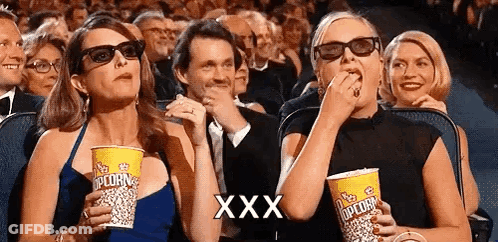 Two Women Eating Popcorn In Theater GIF
