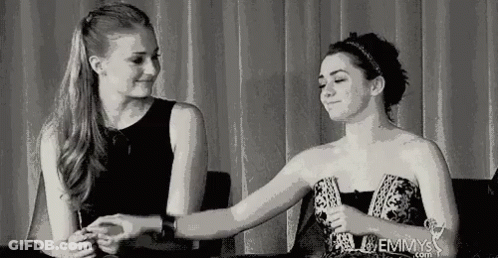 Two Women Facing Each Other One In White Tank Top GIF
