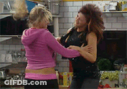 Two Women Fighting In Kitchen, One In Pink Hoodie GIF