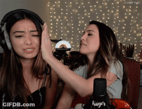 Two Women High Fiving In Front Of Kuger Microphone GIF