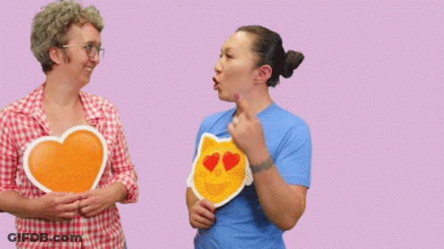 Two Women Holding Signs That Say No You 'Re Awesome On A Pink Background GIF
