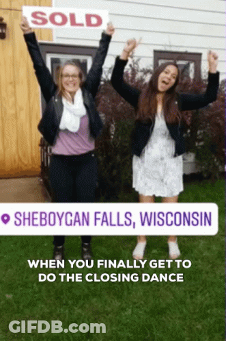 Two Women Holding Sold Sign In Front Of House In Sheboygan Falls Wisconsin GIF