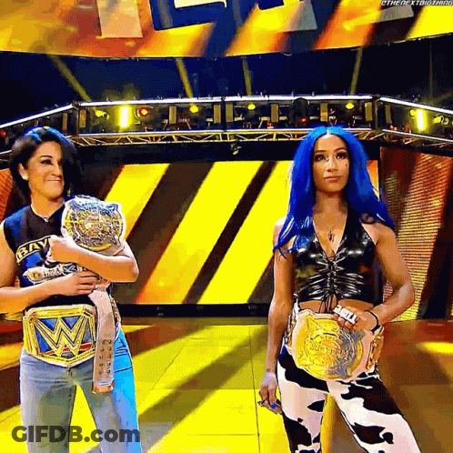 Two Women Holding Wrestling Belts On Stage GIF