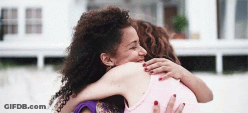 Two Women Hugging And Smiling On Beach GIF