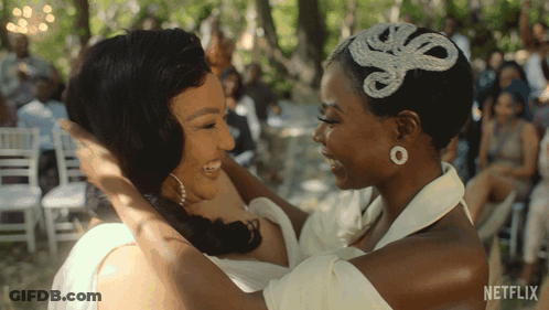 Two Women Hugging Each Other With A Netflix Logo In The Background GIF