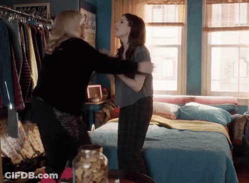Two Women Hugging In A Bedroom With A Jar Of Cookies In The Foreground GIF