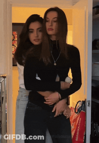 Two Women Hugging In Front Of Red Bershka Bag GIF