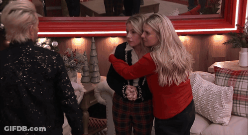 Two Women Hugging, One In Red Sweater GIF