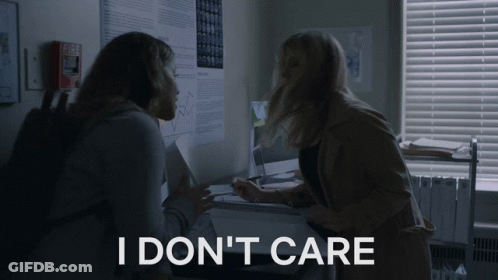 Two Women In A Dark Room With The Words I Don 'T Care On The Bottom Right GIF