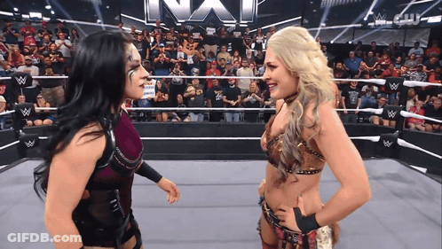 Two Women In A Wrestling Ring With The Word Nxt On The Wall GIF
