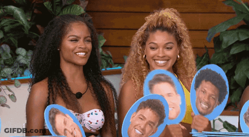 Two Women In Bikinis Holding Portraits GIF