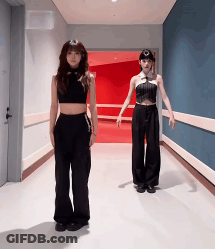 Two Women In Black In Hallway GIF