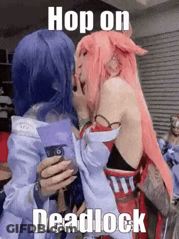 Two Women In Cosplay Hugging And Holding Cell Phone GIF
