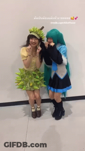 Two Women In Costumes Standing Next To Each Other GIF