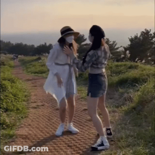 Two Women In Face Masks On Dirt Road GIF