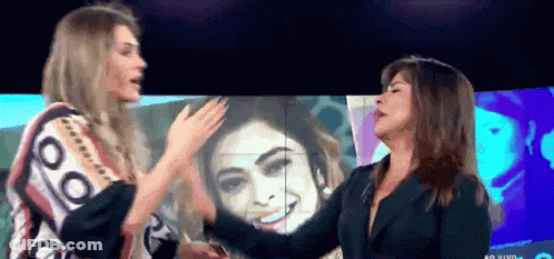 Two Women In Front Of Ao Vivo Screen GIF
