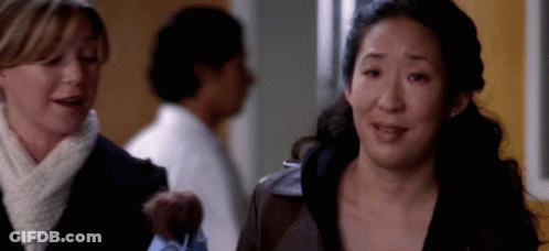 Two Women In Hallway One Holding Teddy Bear GIF