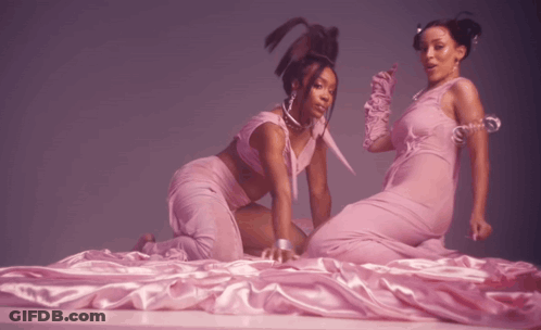 Two Women In Pink Dresses Laying On Bed GIF
