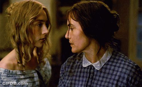 Two Women In Plaid Shirts Are Looking At Each Other GIF