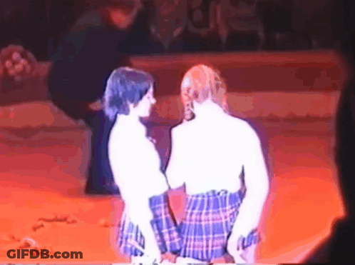 Two Women In Plaid Skirts Dancing On Stage GIF