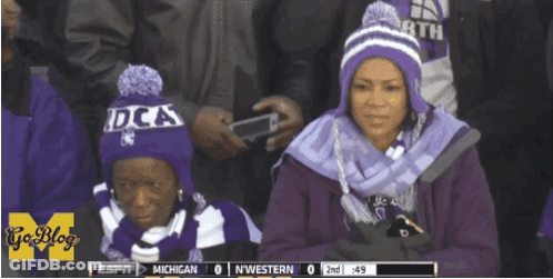 Two Women In Purple Hats Watching Michigan Vs Northwestern GIF