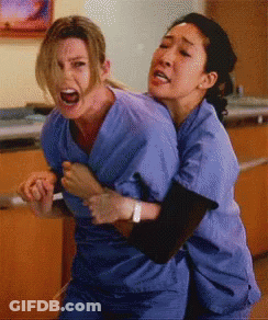 Two Women In Scrubs Hugging With One Screaming GIF