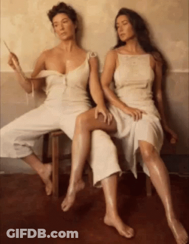 Two Women In White Dresses On Wooden Bench GIF
