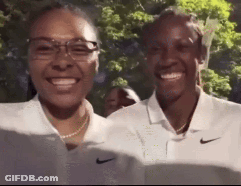 Two Women In White Nike Polo Shirts Smiling At Camera GIF