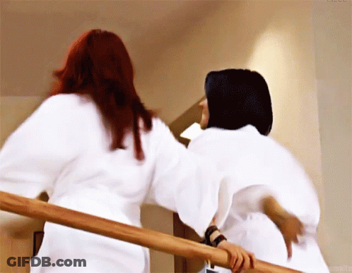 Two Women In White Robes Standing On Stairs GIF