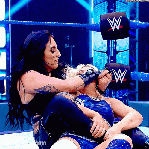 Two Women In Wrestling Ring With W On Wall GIF