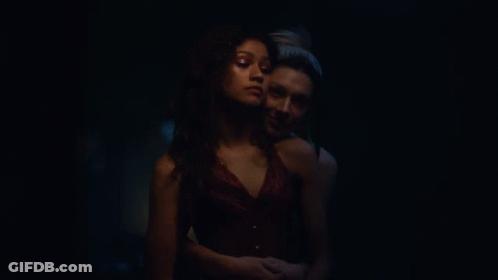Two Women Kissing In Dark Room With Painting GIF
