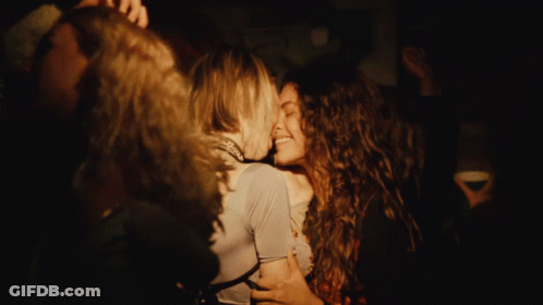 Two Women Kissing In Dark Room With Painting GIF