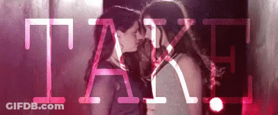 Two Women Kissing In Front Of Pink Take GIF