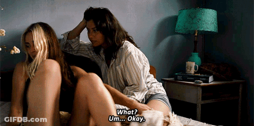 Two Women Laying On Bed Saying What Okay GIF