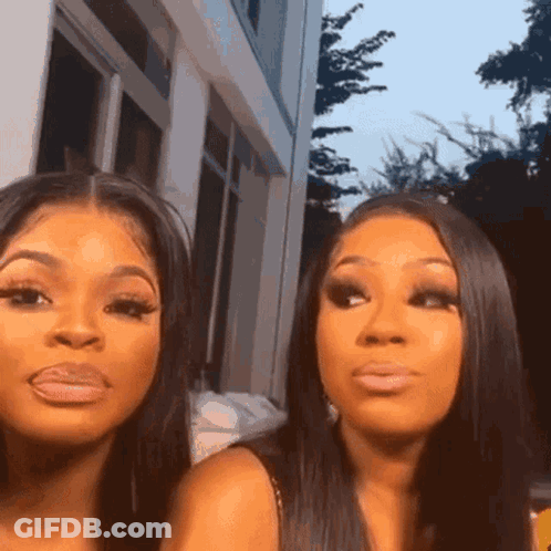 Two Women Looking At Camera In Front Of Building GIF