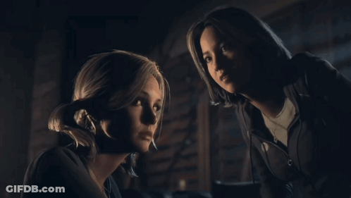 Two Women Looking At Each Other In Dark GIF