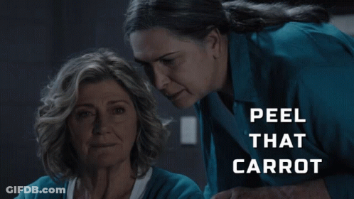 Two Women Looking At Each Other Saying Peel That Carrot GIF