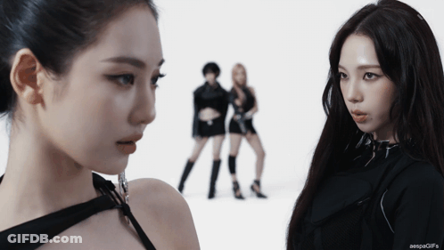 Two Women Looking At Each Other With The Words Aespagifs On The Bottom Right GIF