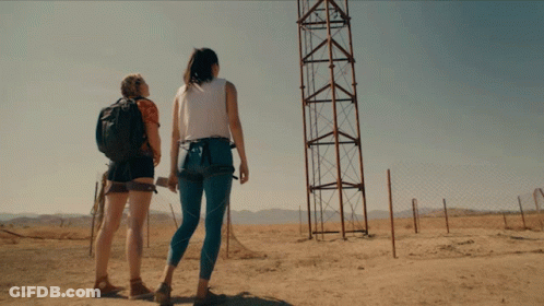 Two Women Looking At Tower In Field GIF