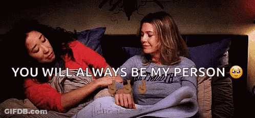 Two Women Lying In Bed Holding Hands GIF