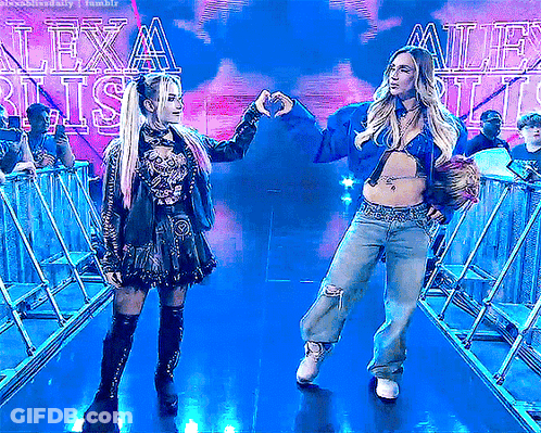 Two Women Making Heart Shape In Front Of Lexa Blitz Sign GIF
