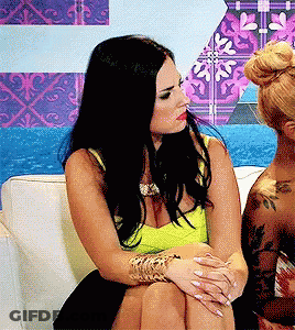 Two Women On Couch Legs Crossed One With Tattoo GIF