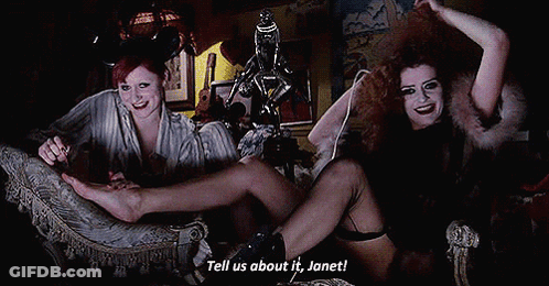 Two Women On Couch Saying Tell Us About It Janet GIF