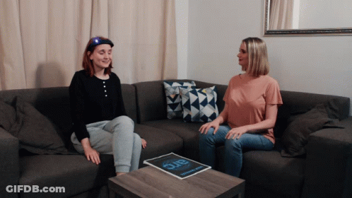 Two Women On Couch With Magazine Saying Arc GIF