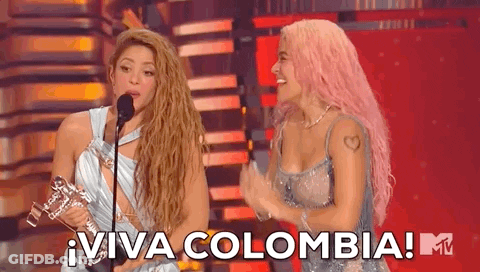 Two Women On Stage With Microphone And Trophy GIF