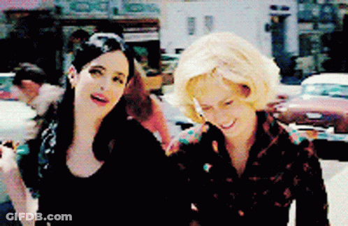 Two Women On Street, One Smoking GIF