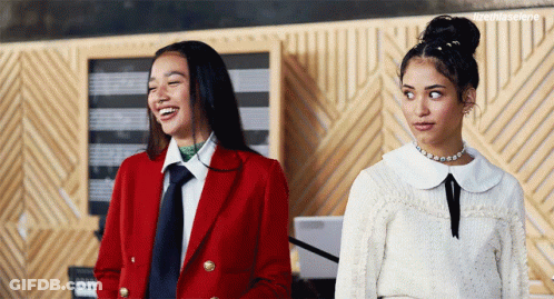 Two Women One In Red Coat Standing Together GIF